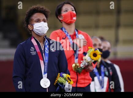 Silver medalist Amandine Buchard from France listens to Japan's national anthem as she stands next to gold medalist Uta Abe from Japan after the Women's Judo 52kg competition at the Tokyo Summer Olympics in Tokyo, Japan on Sunday, July 25, 2021.   Photo by Bob Strong/UPI.. Stock Photo