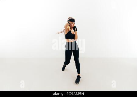 Woman doing boxing workout holding hand weights. Female doing