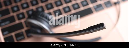 Black head set lying on laptop keyboard closeup Stock Photo