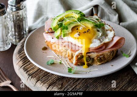 Close up of ham, egg and avocado toast ready for eating. Stock Photo