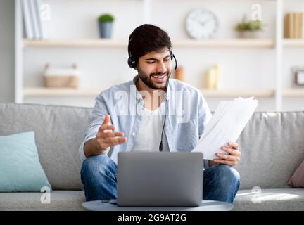 Virtual meeting. Confident arab businessman having video conference, working with financial documents online distantly Stock Photo