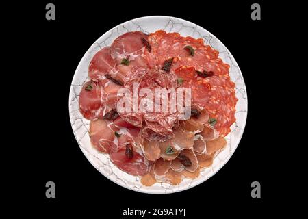 Cold cuts and sausage on plate isolated on black background Stock Photo