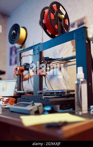 Soft focus of contemporary machines for plastic 3D models printing placed on desk in workshop Stock Photo