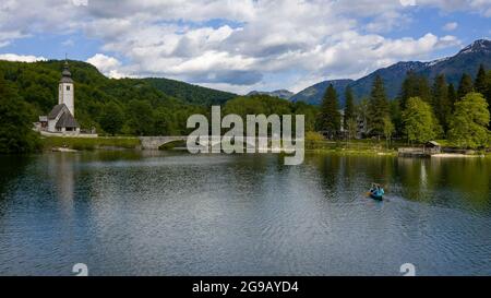 Aerial bird eye shot of a canoe with two person paddling, on beautiful turquoise lake water