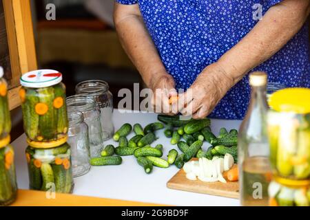 Grandmother manufacturing homemade canning fresh, bio cucumber from her garden, food concept Stock Photo