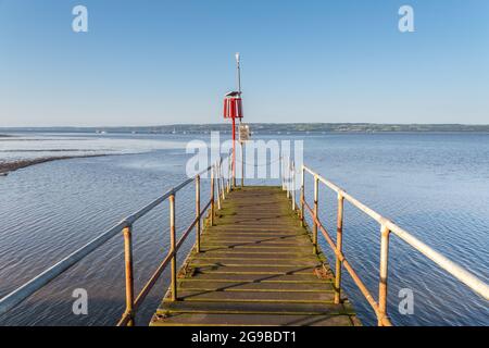 West Kirby, Wirral, UK. Jetty and port lateral mark, used by West Kirby Sailing Club to transport members to and from yachts on the River Dee Stock Photo