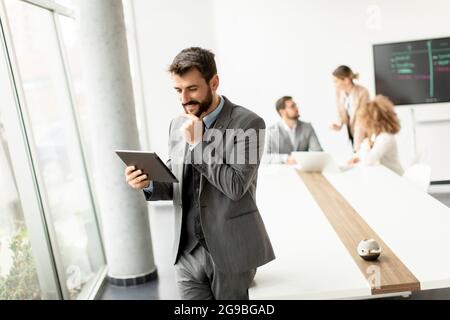 Handsome young modern businessman using digital tablet in the office Stock Photo