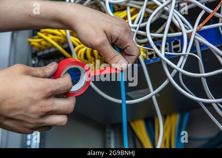 Electrician fixing wires with insulating tape indoors Stock Photo - Alamy