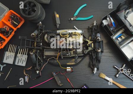 Young Caucasian male assembling toy RC car at home in the evening Stock Photo