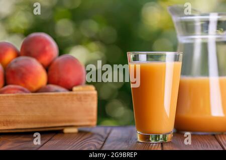 fresh peach juice in glass and jug in the garden Stock Photo