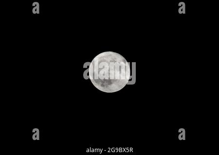 Close up of full moon shining against dark sky Stock Photo
