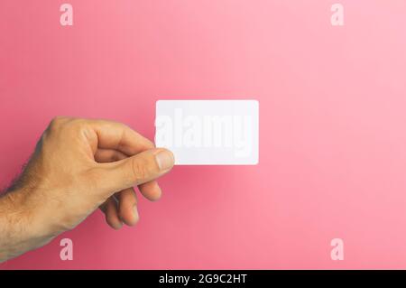 Empty plastic card in hand on colored background. ID or credit money card isolate. High quality photo Stock Photo