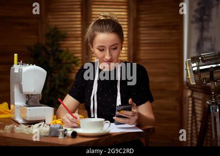Beautiful young seamstress working on sewing machine Stock Photo