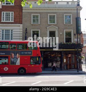 London, Greater London, England, June 12 2021: A bus passes by The Bunch of Grapes pub on Brompton Road in Knightsbridge. Stock Photo