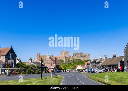 Iconic Bamburgh Castle, a Grade I listed building on the north-east coast of England, seen from the village of Bamburgh in Northumberland on a sunny d Stock Photo