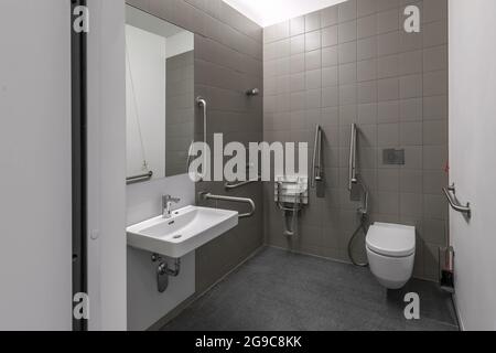 Public restroom for disabled handicapped people with special equipment Stock Photo