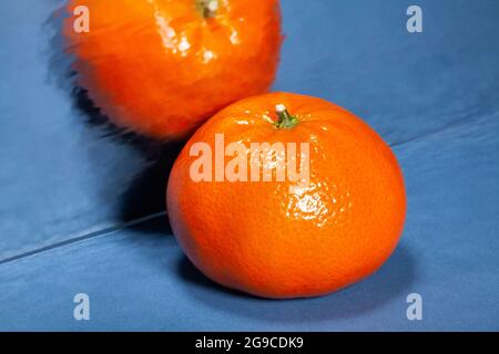 mirrored tangerine on blue background Stock Photo