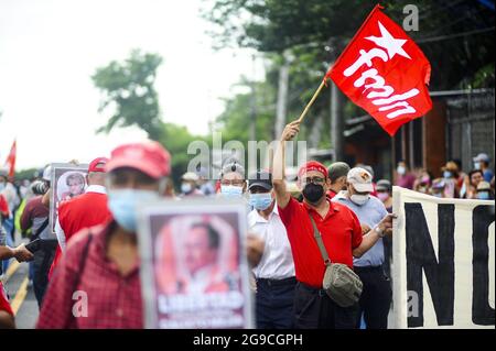 San Salvador, El Salvador. 25th July, 2021. A man waves an FMLN flag during the demonstration. Five former officials from the first government of leftist FMLN (Frente Farabundo Martí para la Liberación Nacional) were accused of corruption charges by the Attorney General's office. FMLN supporters protest said decision calling this a political imprisonment as the current attorney general was imposed by the ruling party after ousting the constitutional attorney and five top judges. Credit: SOPA Images Limited/Alamy Live News Stock Photo