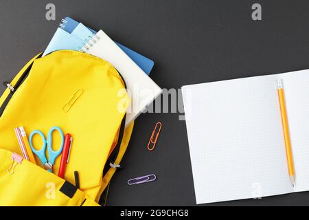 School supplies in a yellow backpack. Stock Photo