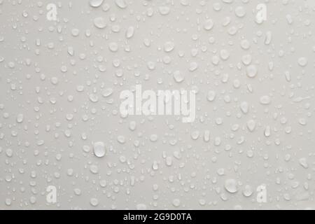 Water droplets on shiny white metallic surface Stock Photo