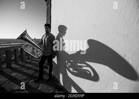 A musician with a tuba on the seashore. Black and white photo. Stock Photo