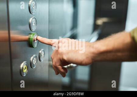 Close up of unrecognizable man pushing buttons in elevator, copy space Stock Photo