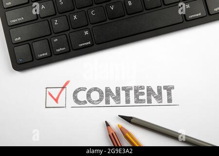 CONTENT. Computer keyboard and pencils on a white table. Stock Photo