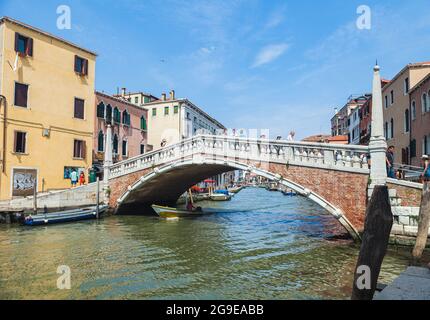 VENICE, ITALY - JUNE 15, 2016 View of the Ponte delle Guglie Bridge of Spires over the Canaregio Canal on a bright sunny day. A crowd of tourists on the bridge. Stock Photo