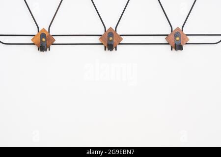 Empty hanger with black metal and wooden elements on white textured wall Stock Photo