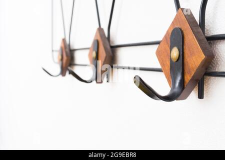 Empty hanger with black metal and wooden elements on white textured wall Stock Photo
