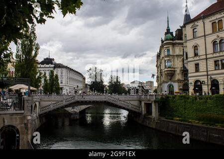 Ljubljana, Slovenia - July 15, 2017: View of Ljubljanica River and Triple Bridge in Ljubljana Downtown on a Cloudy Day Stock Photo