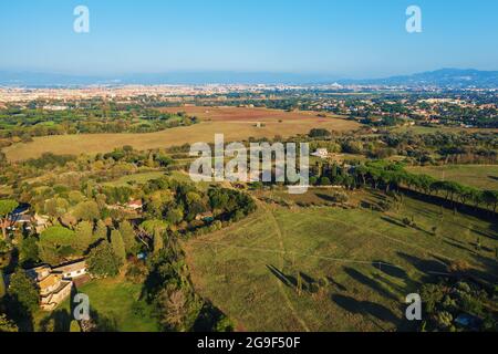 Aerial view of ancient Via Appia Antica with green trees, meadows, houses and pathways in Rome, Italy. Stock Photo