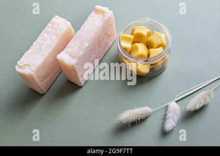 Body massage tiles made of natural cocoa butter and aromatic oils in a jar. A bar of natural handmade citrus soap. Care for dry skin of the body. Home Stock Photo