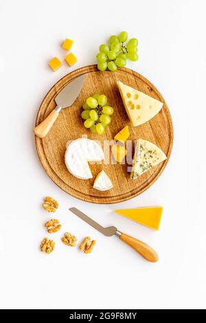 Set of cheese on wooden board with cheese knives, top view Stock Photo