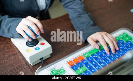 Woman with cerebral palsy works on a specialized computer. Stock Photo