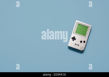 Vintage retro hand held games console on a pastel blue background with copy space and room for text Stock Photo