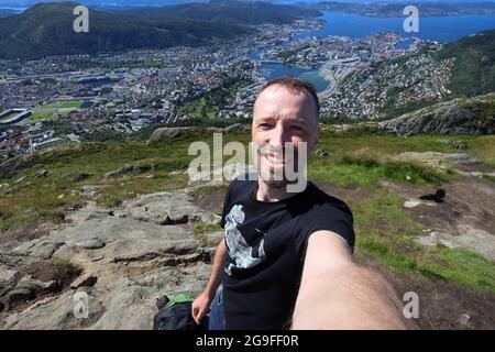 Tourist selfie in Norway hiking area - mountain trail Ulriken above city of Bergen. Outdoor recreation activity. Stock Photo