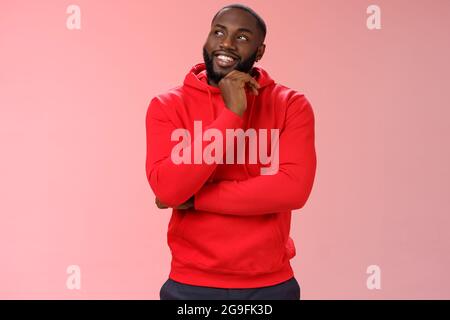 Inetersted successful young black sportsman considering take opportunity look curious upper left corner thinking touch chin thoughtful, make decision Stock Photo