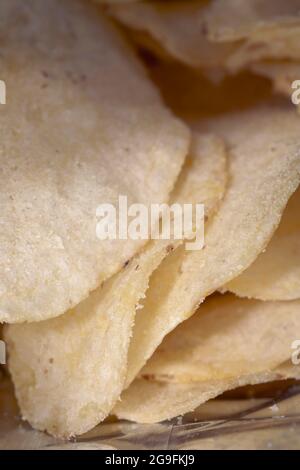 Potato chips in a bundle close up. Crispy Potato chips to eat from bag as snack with calories and cholesterol crisp closeup. Stock Photo