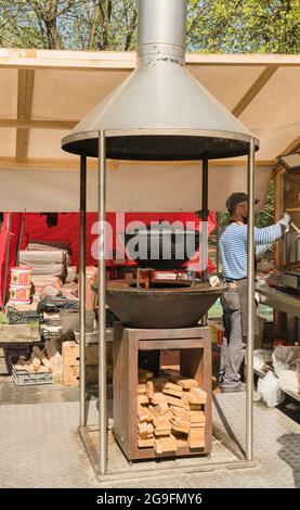 Kaliningrad, Russia - may 10, 2021: view of  cauldron with food in the oven and chefs cooking meal on background at food fair Stock Photo