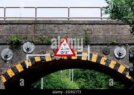 Height restriction sign on a railway bridge, Warwick, UK Stock Photo