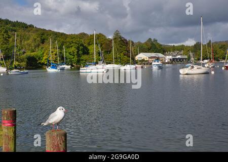 A lakeside scene with boats on their moorings in the Lake District, Cumbria, England, UK