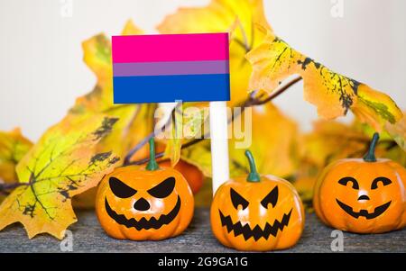 Colorful Halloween background with smiley pumpkins and toy flag of bisexual Stock Photo