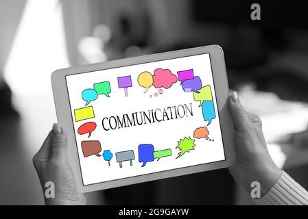 Communication concept shown on a tablet held by a woman Stock Photo