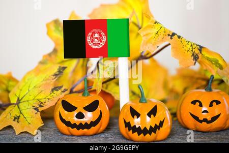 Colorful Halloween background with smiley pumpkins and toy flag of Afghanistan Stock Photo