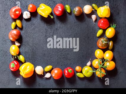 Frame made of assortment of colorful fresh vegetables on black background. Flat lay, top view. Stock Photo