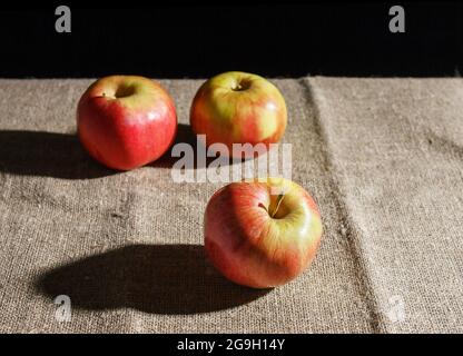 three red apples on the table. closeup on black background Stock Photo