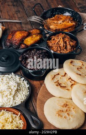 Table served with Venezuelan breakfast, arepas with different types of fillings such as black beans, shredded meat , leg, fried plantain and cheese Stock Photo