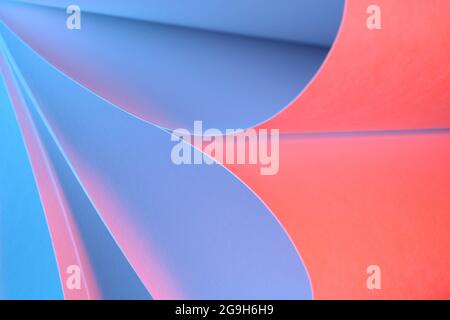 Beautiful creative image of plain white paper scrolls coloured red, pink and yellow by the use of coloured flash lighting Stock Photo