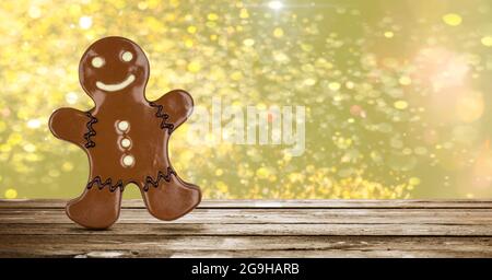 Chocolate gingerbread man on wooden table with shiny background Stock Photo